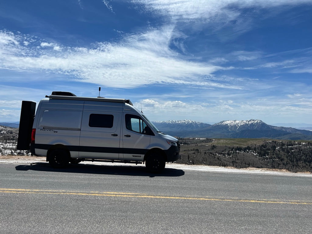 Silver Winnebago Revel 4x4 camper van on a mountain overlook. Great for your next RV rental adventure!