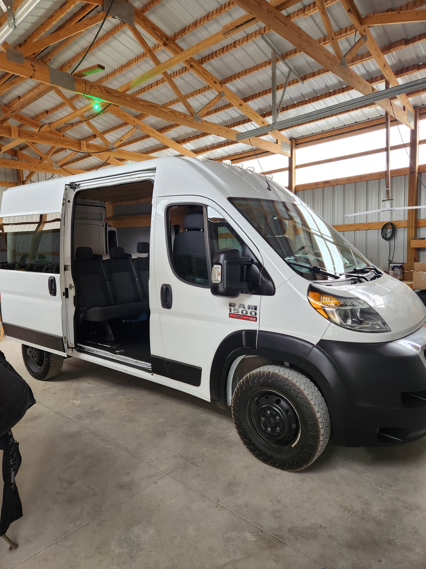 White Ram ProMaster passenger van, side door open, in a garage. Ideal for your next RV rental adventure.