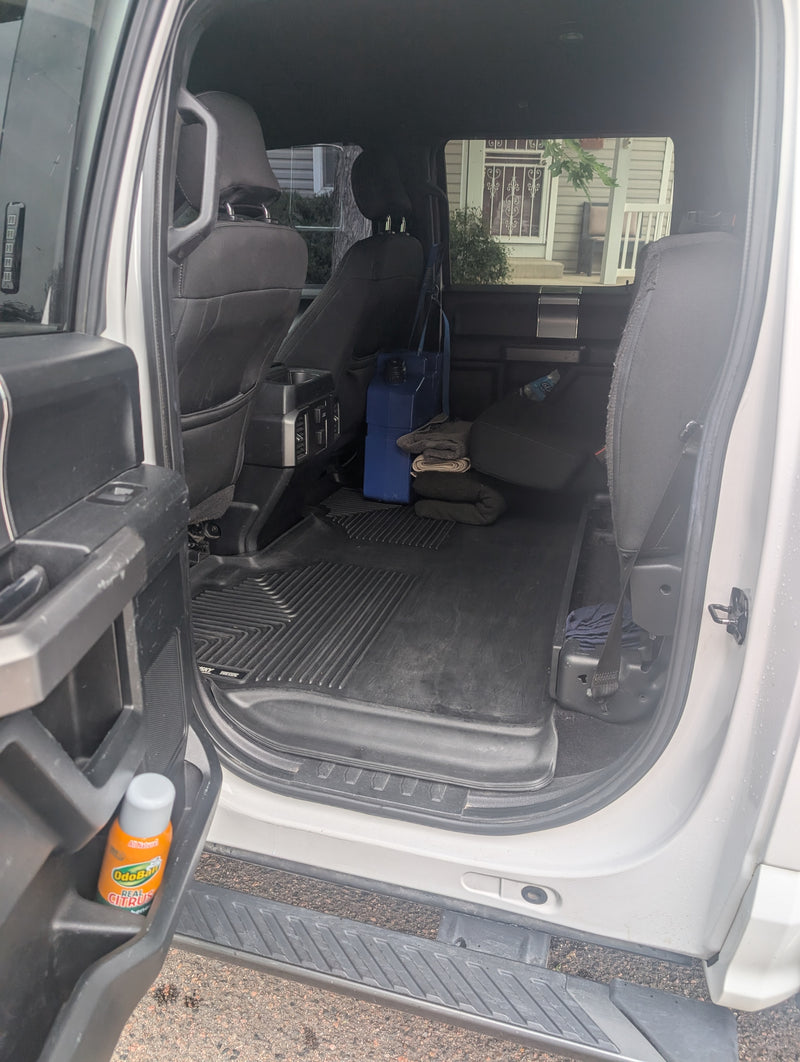 Rear interior of a large vehicle, showing flexible cargo space, floor mats, blue container, and blankets. Great for an RV rental. — photo 18