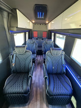 Experience a premium rv rental! Interior shows spacious black quilted leather seats, wood flooring, and blue accent lighting.