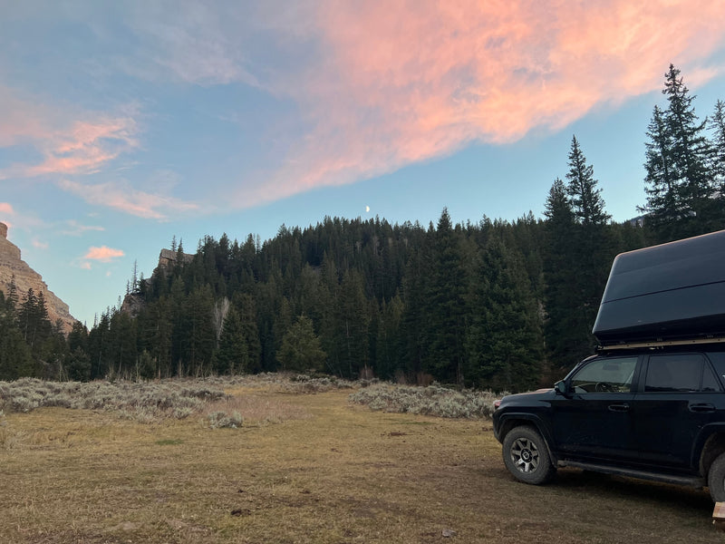 RV rental adventure! Sunset wilderness camping with an SUV & rooftop tent, nestled among mountains and a forest under a crescent moon. — photo 15
