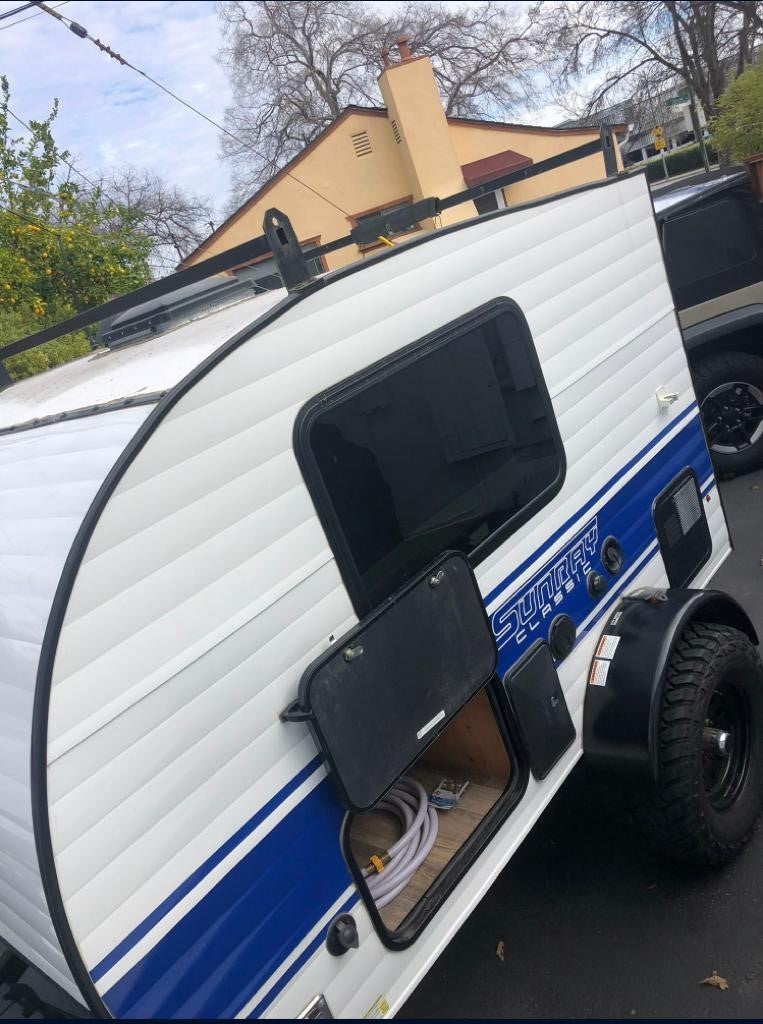 Compact Sunray Classic teardrop RV rental, featuring outdoor storage and rugged tires for adventure.