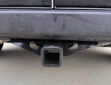Close-up of an RV rental vehicle's rear bumper and heavy-duty black towing hitch receiver, ready for trailer hook-up.