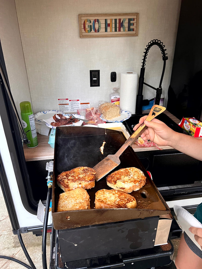Cooking French toast and bacon on a griddle in an RV rental's outdoor kitchen. A perfect camping breakfast. — photo 6
