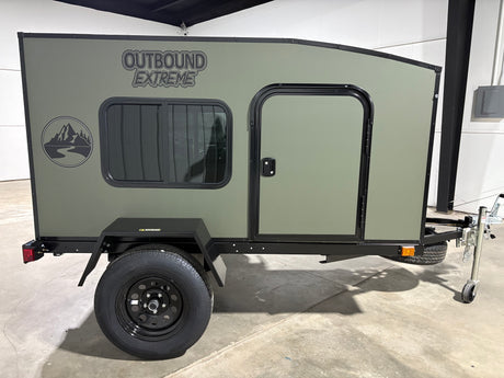 Olive green 'Outbound Extreme' compact camper trailer, ideal for RV rental and outdoor adventures.