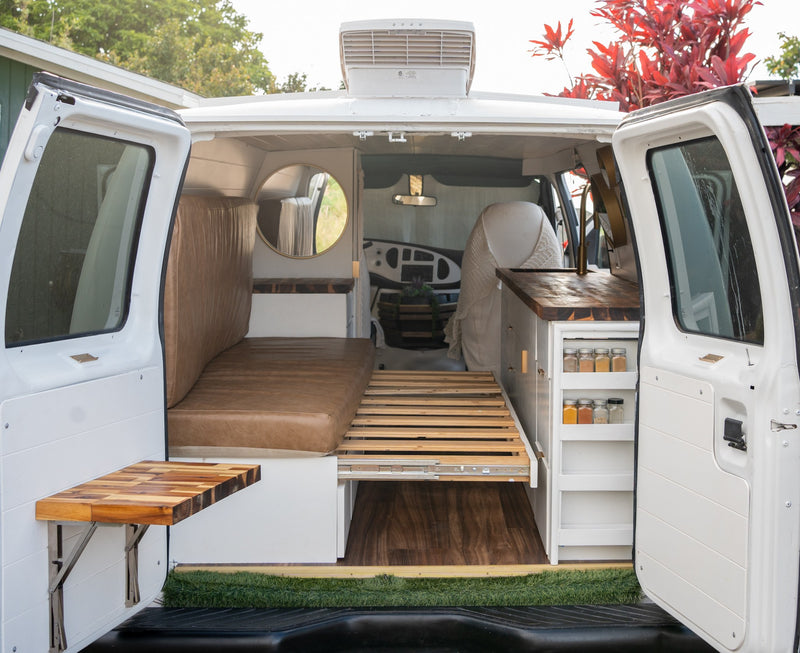  and folding table. Ready for adventures.|Inside this modern **rv rental** van: a cozy bench/bed — photo 2