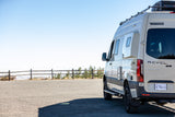 Adventure awaits! This Winnebago Revel 4x4 camper van, perfect for rv rental, is parked at a scenic overlook.