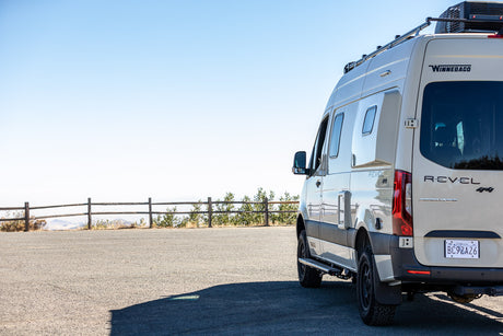 Adventure awaits! This Winnebago Revel 4x4 camper van, perfect for rv rental, is parked at a scenic overlook.