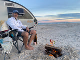 Enjoying beach camping by our RV rental, cooking dinner over a beach bonfire at sunset. A perfect, relaxing getaway!