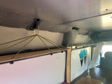 Clever hanging shelves offer storage in this Wayfarer Vans rv rental, showcasing a custom van interior.