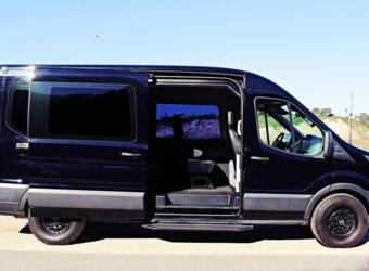  ideal for comfortable group travel.|A black Ford Transit conversion van — photo 8