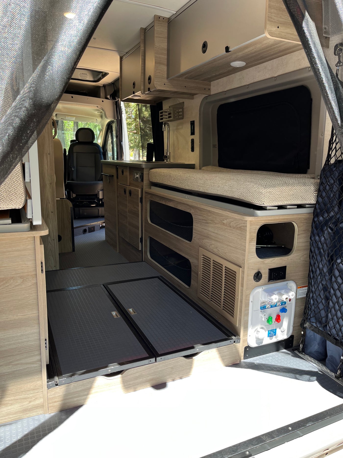 Inside this modern RV rental: a compact kitchen, comfortable bed area, and versatile storage for your road trip adventures. — photo 11