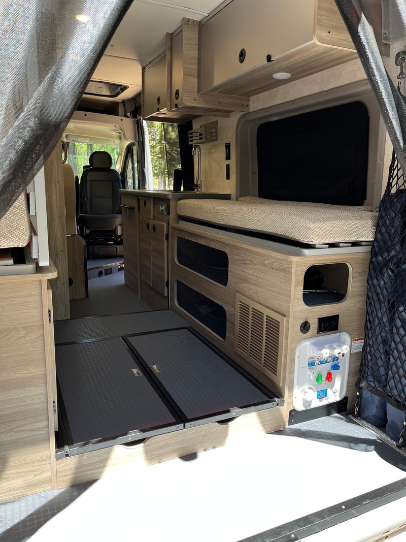 Inside this modern RV rental: a compact kitchen, comfortable bed area, and versatile storage for your road trip adventures. — photo 11