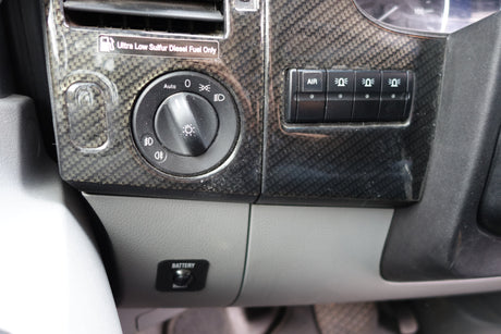 RV rental interior: Dashboard with light controls, auxiliary switches, diesel fuel reminder, and battery boost button.