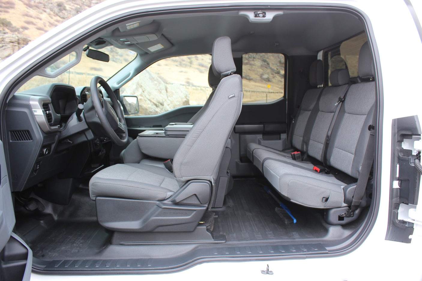 Spacious vehicle interior, perfect for an rv rental. Shows driver's seat, dashboard, rear bench, and durable floor mats.