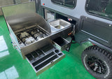 RV rental camper with a slide-out stainless steel outdoor kitchen: 3-burner gas stove, sink, and utensil drawers. Perfect for camping!