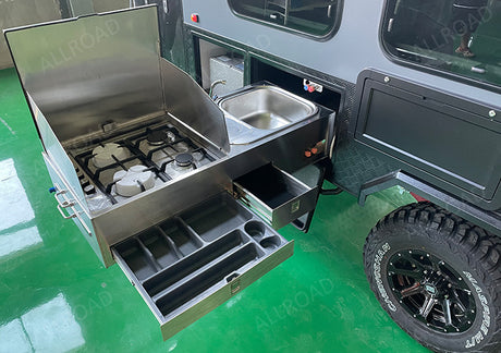 RV rental camper with a slide-out stainless steel outdoor kitchen: 3-burner gas stove, sink, and utensil drawers. Perfect for camping!