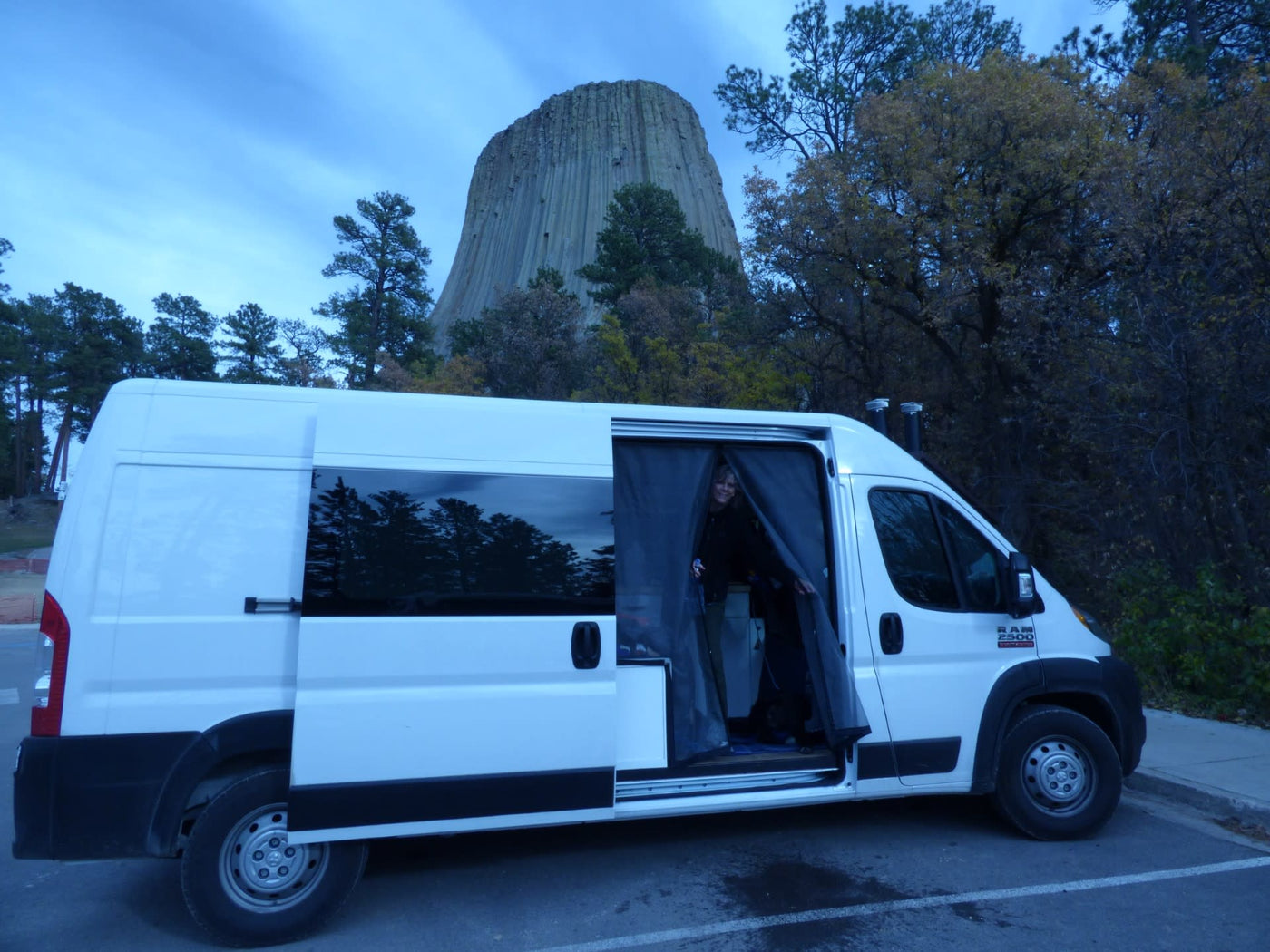  with a visitor viewing the historic grounds and American flag.|A white RAM ProMaster van