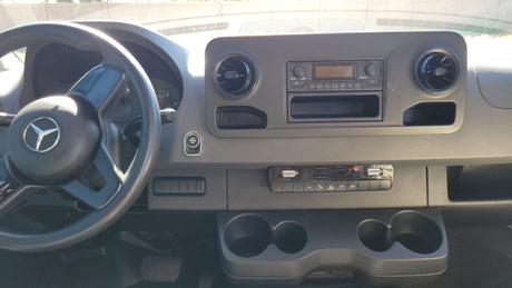Dashboard of a Mercedes-Benz Sprinter van, often used as an **rv rental**, with steering wheel, radio, and climate controls.