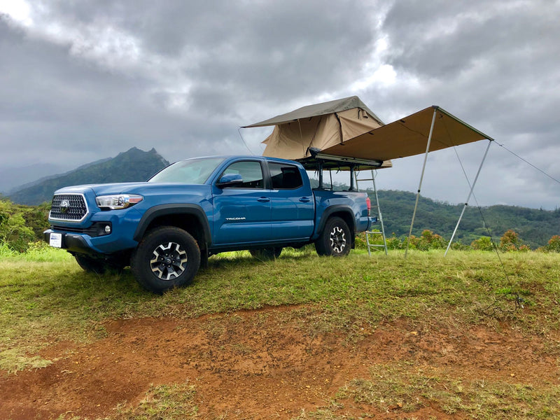 Blue Toyota Tacoma with rooftop tent & awning setup. Perfect for your next rv rental adventure with scenic mountain views! — photo 4