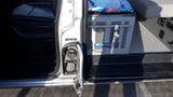 RV rental interior: Engel fridge/freezer, passenger seat, & open door with fuel cap visible. Ready for your journey.