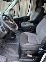 Spacious RV rental cabin, showing the steering wheel, dashboard, and two comfortable front seats, perfect for road trips.