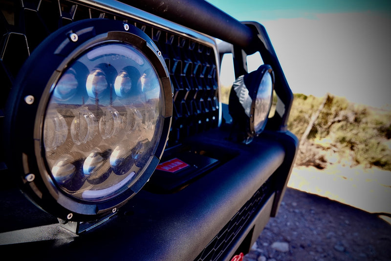 Detail of an RV rental off-road vehicle's LED light, reflecting a desert landscape and utility poles. — photo 13