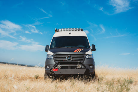 Custom Mercedes Sprinter adventure van, perfect for rv rental, parked in a golden field under blue sky.