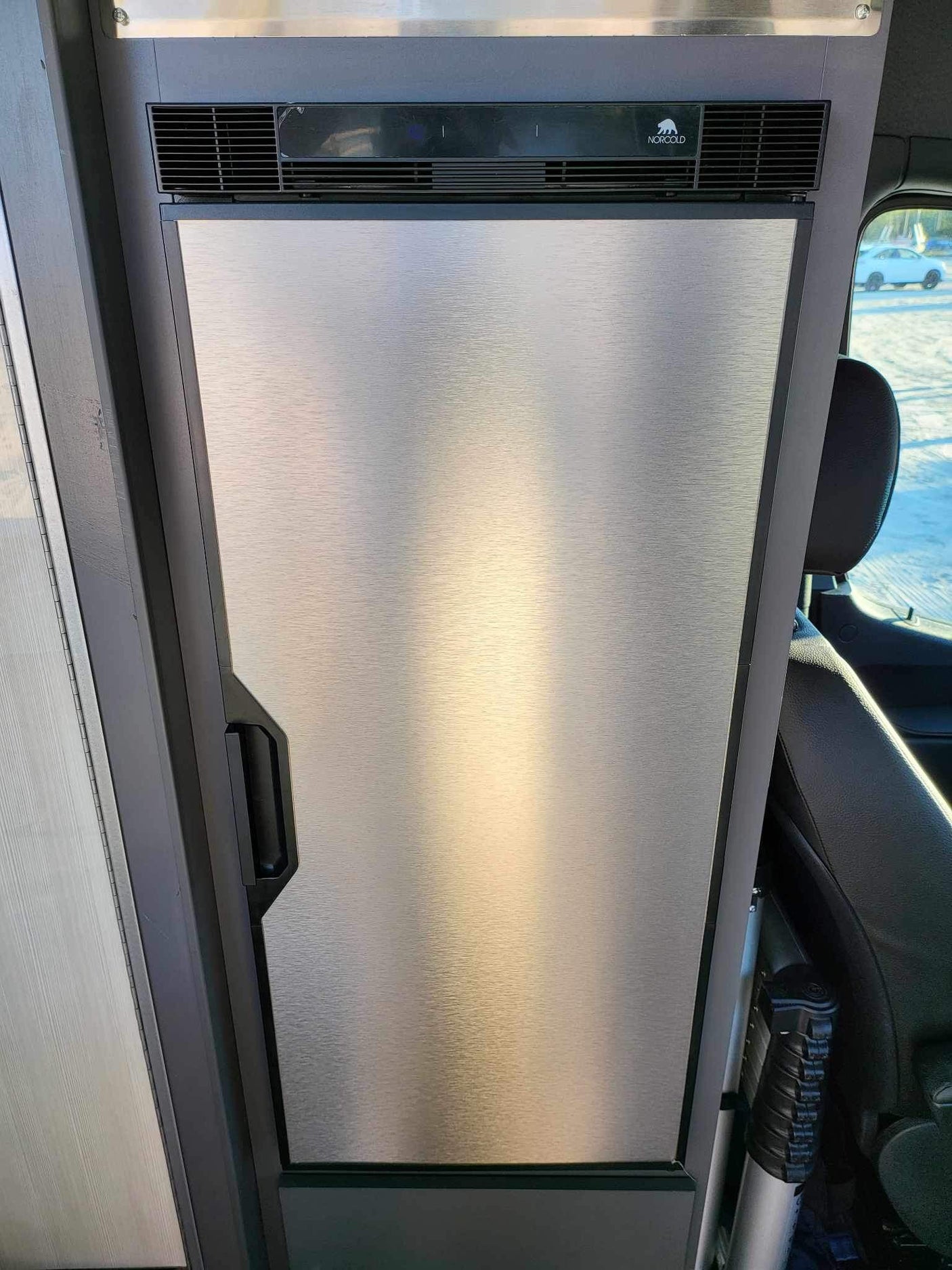 Sleek Norcold RV refrigerator with brushed stainless steel door and integrated handle, found in this RV rental.