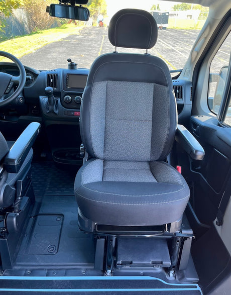 Inside this RV rental: front passenger swivel seat with armrests, dashboard, and road view. Ideal for camper van travel.