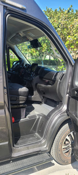 An RV rental van's inviting interior: driver's seat, dashboard, and front passenger area. Ready for your next journey!