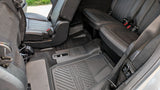 RV rental interior with black leather rear seats and durable, all-weather floor mats for comfortable journeys.