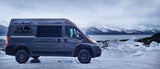 Million Mile Adventures RV rental van on icy shore, with snow-capped mountains across water. Your adventure starts!