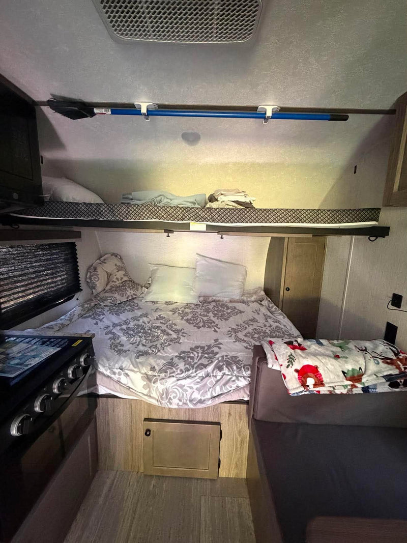  plus a lower bed and an upper bunk.|Compact RV rental bathroom featuring a toilet — photo 4
