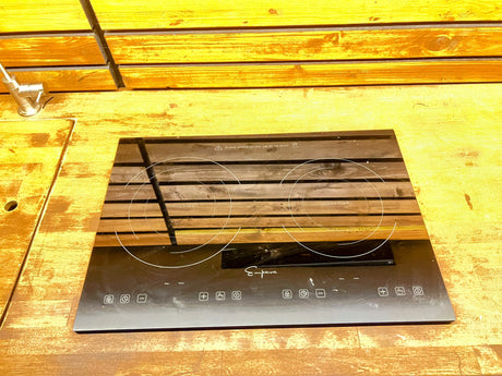 Compact Empara induction cooktop with two burners set in a wood countertop, ideal for an RV rental kitchen experience.