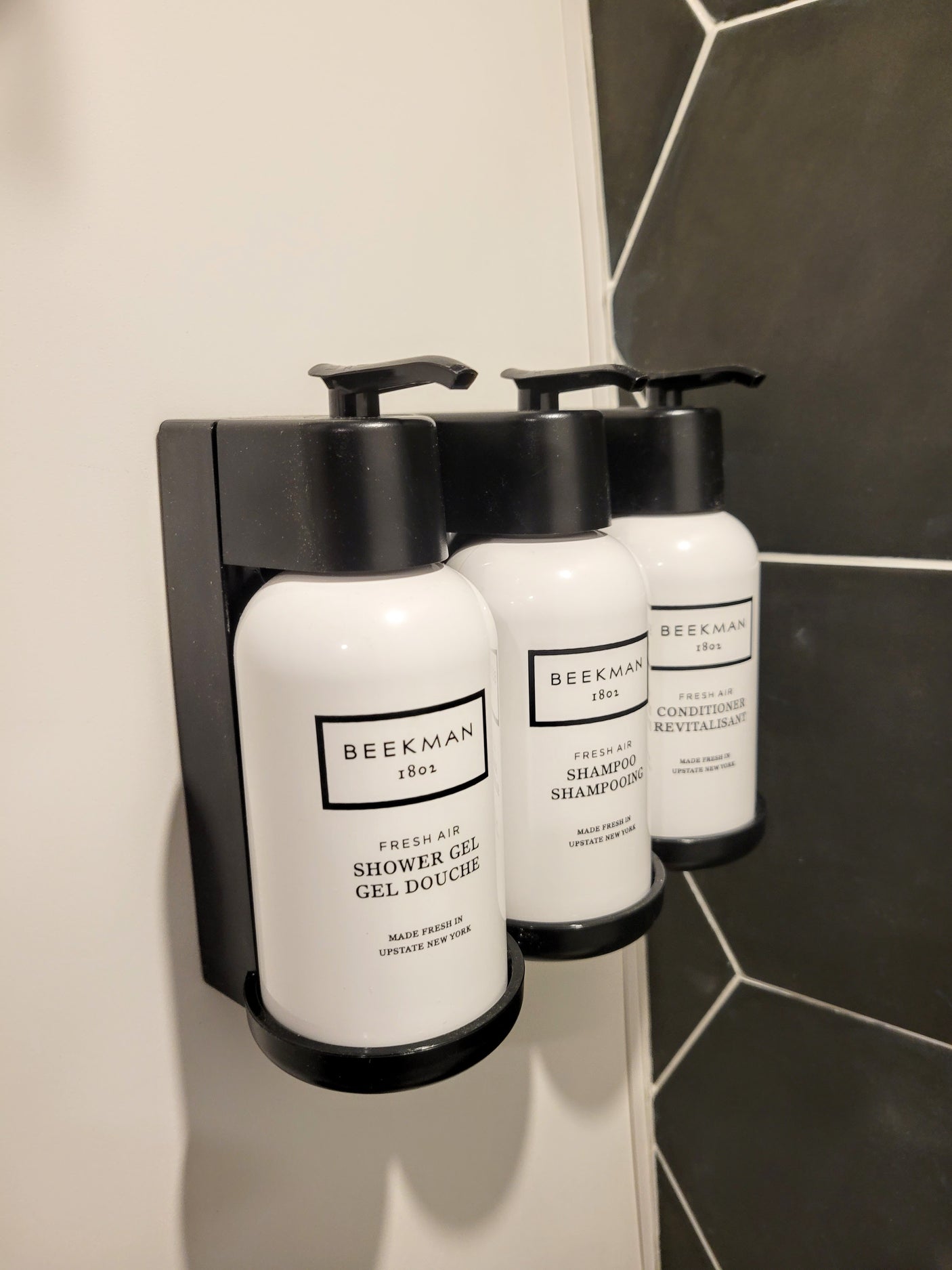 RV rental bathroom: Beekman 1802 shower gel, shampoo, and conditioner in a sleek wall-mounted dispenser.