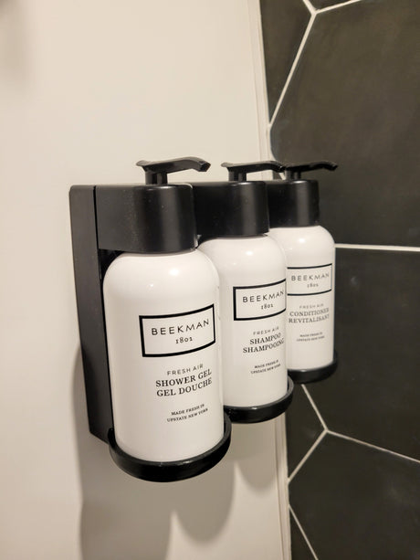RV rental bathroom: Beekman 1802 shower gel, shampoo, and conditioner in a sleek wall-mounted dispenser.