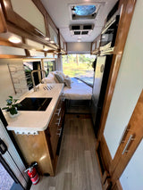 This RV rental showcases a compact kitchen, comfortable rear bed, and efficient living space.