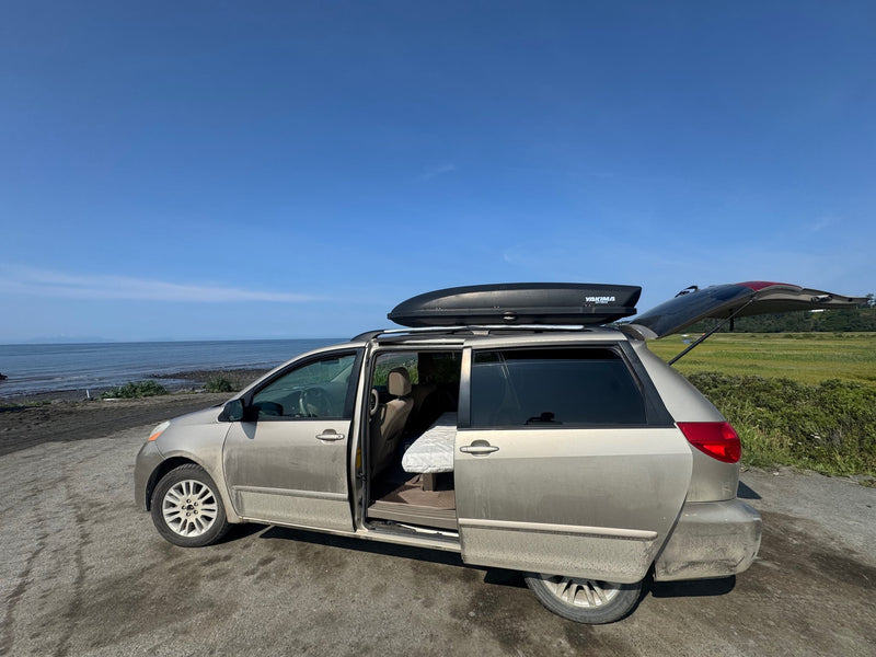  ideal for coastal camping.|A dirty gold minivan with roof box by the ocean — photo 6