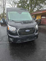 Black Ford Transit van, ideal for RV rental, wet from rain. Parked on a driveway, ready for your next trip.
