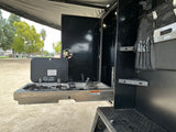 This RV rental features a pull-out Dometic outdoor kitchen with stove, sink, and utensil storage, ideal for camping.