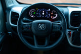 Ram steering wheel and illuminated digital dashboard in an RV rental, showing vehicle controls and gauges.