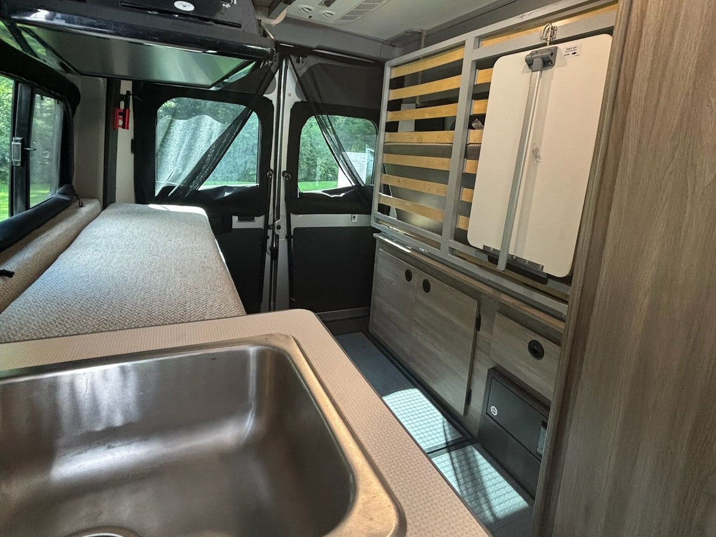  and control panels for a compact living space.|Inside an RV rental: a compact interior features a cushioned bench — photo 5