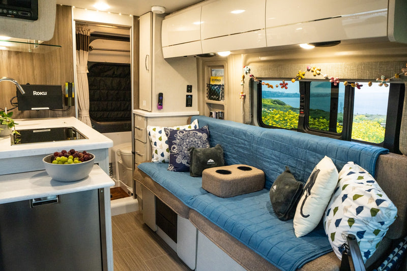 Explore in comfort with this RV rental's spacious interior featuring a kitchen, cozy seating, and scenic window views. — photo 15