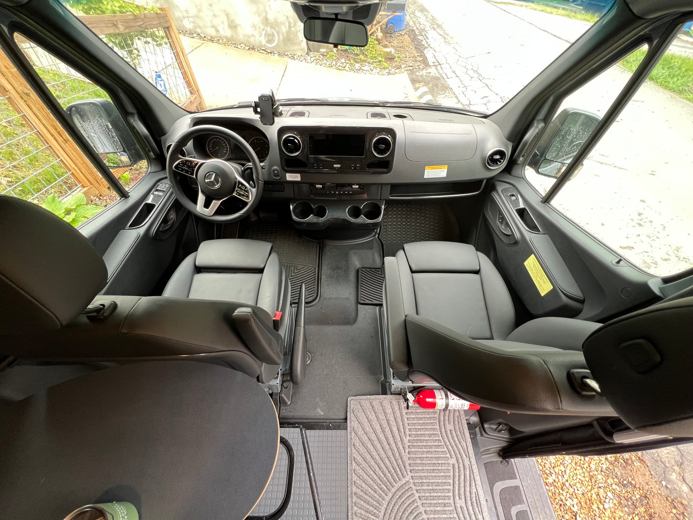 Step inside this modern rv rental van! View of the spacious front cabin with dashboard, comfy seats & fire extinguisher.