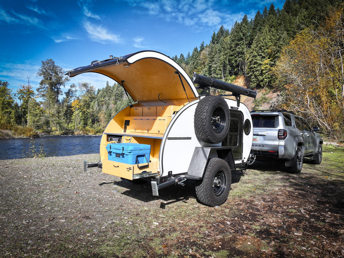  parked by a scenic river and forest.|Overlanding setup: An RV rental teardrop camper and SUV by a scenic river — photo 9