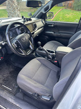 Spacious gray vehicle interior with steering wheel & dashboard. View of green yard outside. Perfect for trips, possibly with an rv rental.