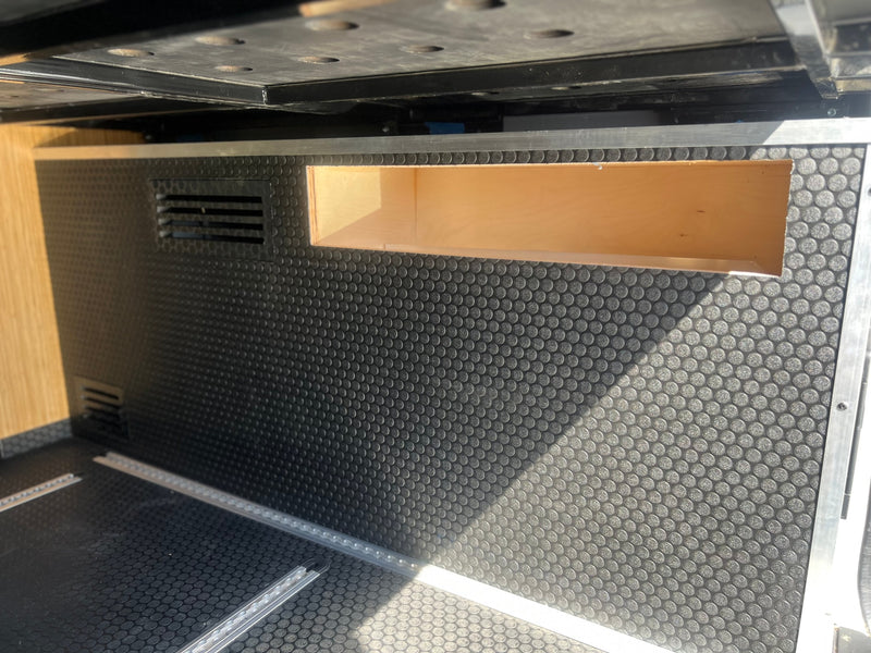 RV rental interior: black textured floor with cargo rails, a wooden storage cubby, and ventilation vents. — photo 20
