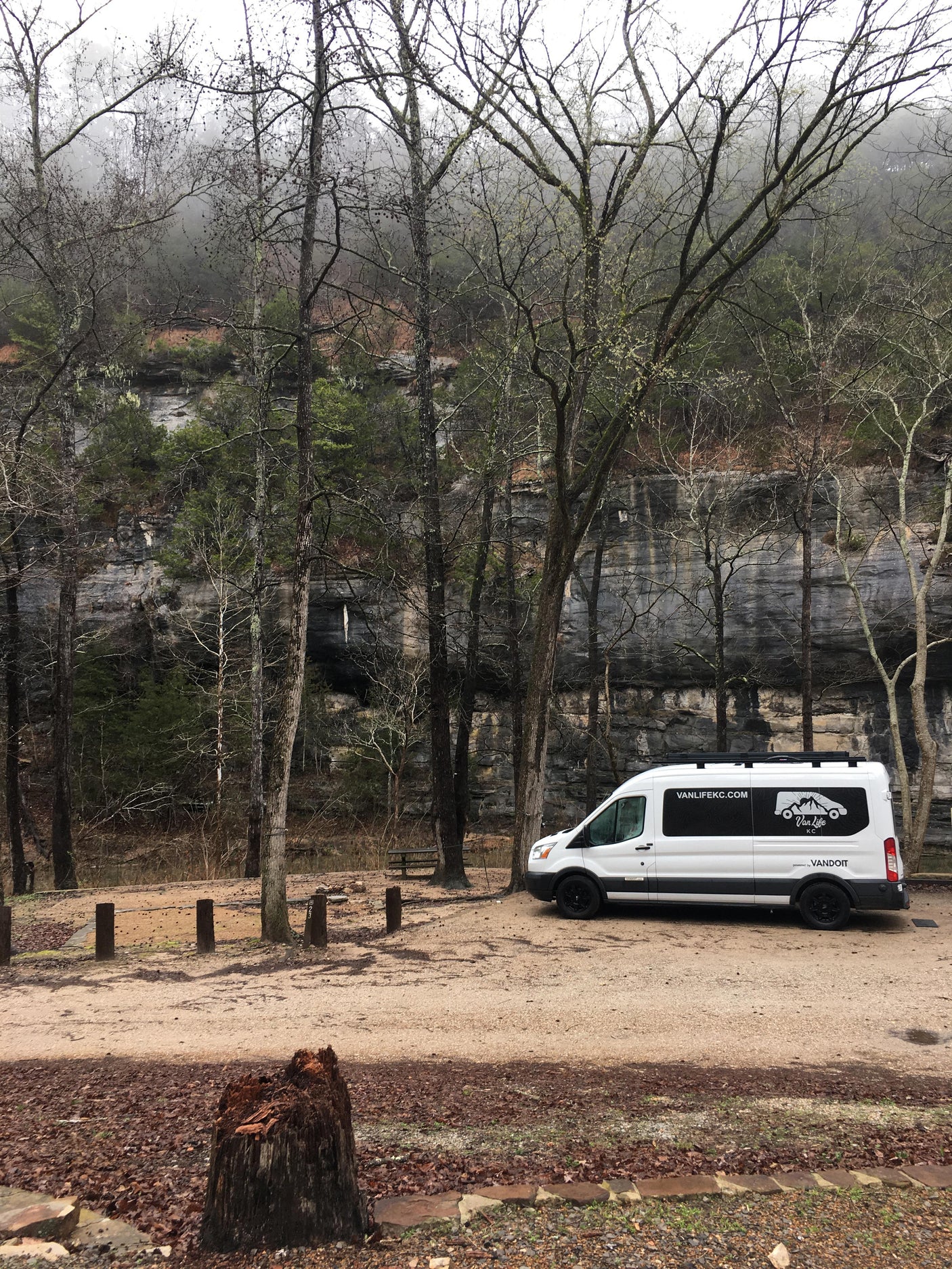 Van Life KC camper van rental at a rocky, forested campsite. An ideal RV rental for exploring nature's beauty.