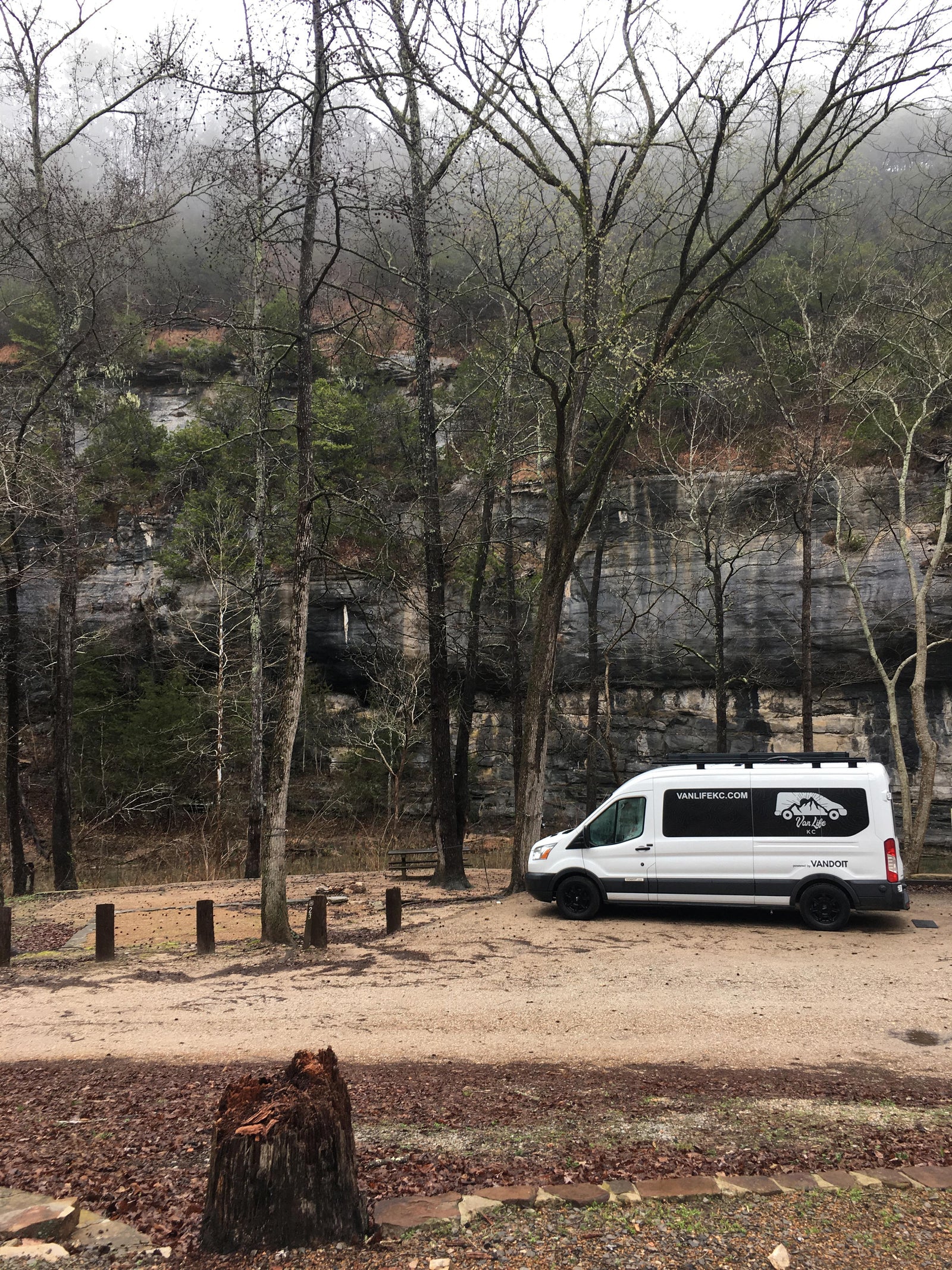 Van Life KC camper van rental at a rocky, forested campsite. An ideal RV rental for exploring nature's beauty.
